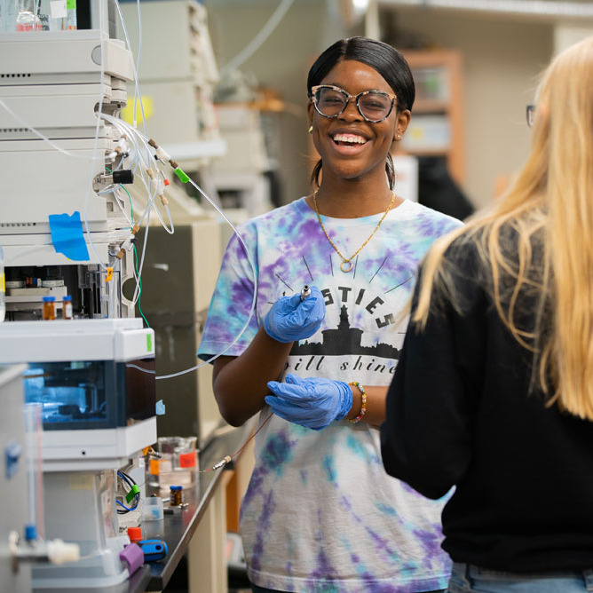 Female African American student laughing while working in a science laboratory