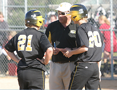 Coach Jeff Annis confers with Kelsie Droogsma and Hannah Spitzack